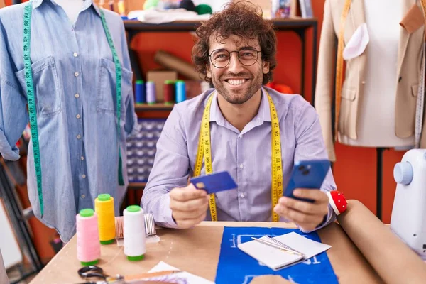Young Hispanic Man Tailor Using Smartphone Credit Card Atelier — Stockfoto