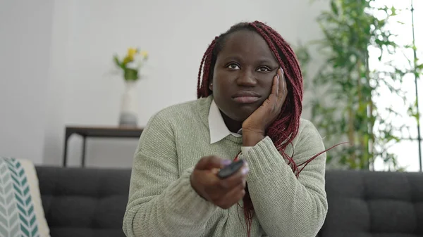 Saçları Örgülü Afrikalı Bir Kadın Kanepede Oturmuş Televizyon Seyrediyor Evde — Stok fotoğraf