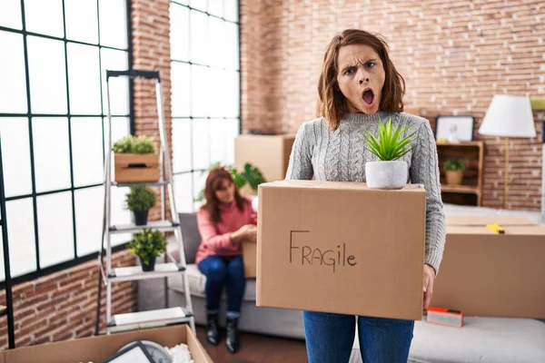 Mother Daughter Moving New Home Holding Cardboard Box Shock Face — Stockfoto