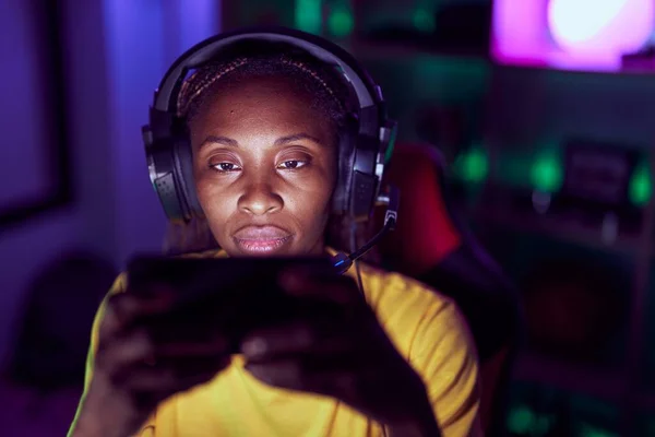 アフリカ系アメリカ人の女性がゲームルームでスマートフォンを使ってビデオゲームをするストリーマー — ストック写真