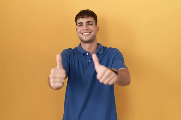 Young Hispanic Man Standing Yellow Background Approving Doing Positive Gesture — Stock Photo, Image