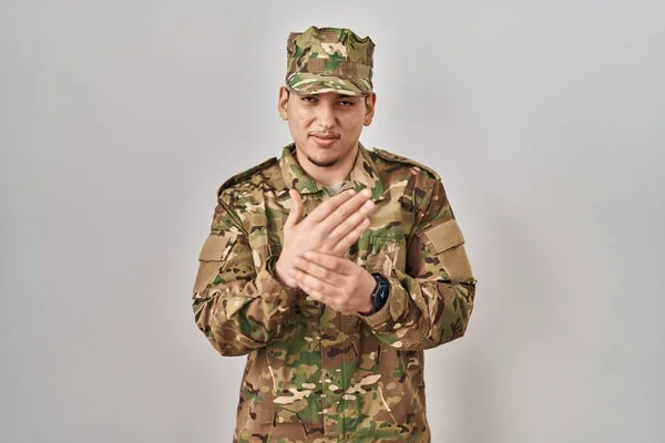 カモフラージュ軍の制服を着た若いアラブ人男性手や指に痛み 関節炎の炎症 — ストック写真