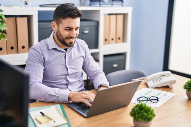 Young hispanic man business worker using laptop working at office