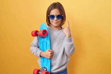 Güneş gözlüğü takan küçük İspanyol çocuk bir fikre ya da soru işaretine şaşırdı ve mutlu bir yüzle işaret etti. 