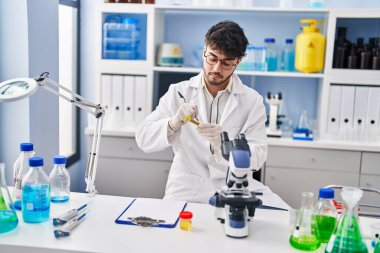 Laboratuvarda test tüpüne yazı yazan genç İspanyol bilim adamı.