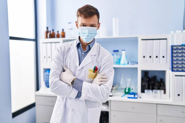 Tıbbi Maske Takan Genç Bir Bilim Adamı Laboratuarda Kollarını Kavuşturmuş — Stok fotoğraf