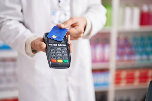 年轻的高加索男子药剂师在药店使用信用卡和数据电话 — 图库照片