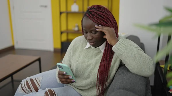 Αφρικανική Γυναίκα Πλεγμένα Μαλλιά Χρησιμοποιώντας Smartphone Ανήσυχη Έκφραση Στο Σπίτι — Φωτογραφία Αρχείου