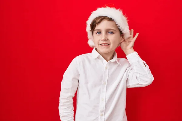 Pequeño Chico Caucásico Con Sombrero Navidad Sobre Fondo Rojo Sonriendo —  Fotos de Stock
