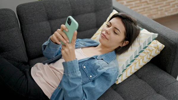 Νεαρή Καυκάσια Γυναίκα Που Χρησιμοποιεί Smartphone Ξαπλωμένη Στον Καναπέ Στο — Φωτογραφία Αρχείου