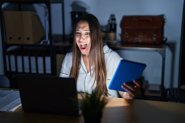 夜のオフィスで働く若いブルネットの女性は怒りと怒りで叫んで フラストレーションと激怒を叫びました 怒りと攻撃的な考え方 — ストック写真