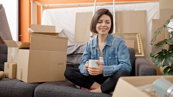 Genç Beyaz Kadın Kanepeye Oturmuş Yeni Evinde Bir Fincan Kahve — Stok fotoğraf