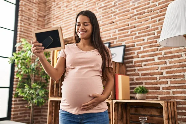 Mujer Latina Joven Embarazada Mirando Foto Casa —  Fotos de Stock