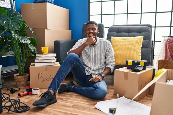 Hombre Afroamericano Sentado Suelo Una Casa Nueva Mirando Confiado Cámara — Foto de Stock