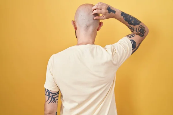 Sarı Arka Planda Dikilen Spanyol Dövmeli Adam Elleri Kafasında Şüpheyi — Stok fotoğraf