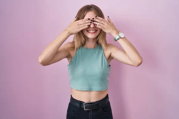 Blonde Caucasian Woman Standing Pink Background Covering Eyes Hands Smiling — Stockfoto