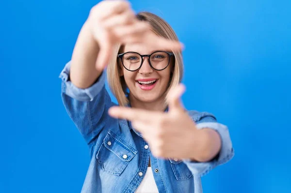 Mavi Arka Planda Duran Beyaz Bir Kadın Gülümsüyor Elleri Parmakları — Stok fotoğraf