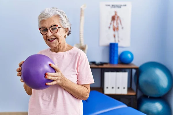 在理疗诊所使用球进行康复治疗的老年灰发妇女理疗患者 — 图库照片