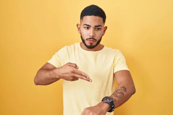 Young Hispanic Man Standing Yellow Background Hurry Pointing Watch Time — Stock Photo, Image