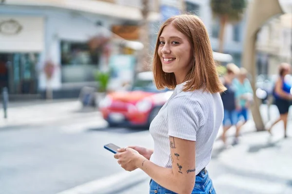 Junge Rothaarige Frau Lächelt Selbstbewusst Mit Smartphone Auf Der Straße — Stockfoto