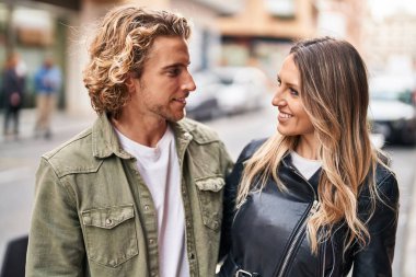 Erkek ve kadın bir arada durarak gülümsüyor.