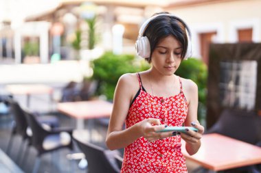 Sokakta konsantre ifadesiyle video oyunu oynayan sevimli İspanyol kız.