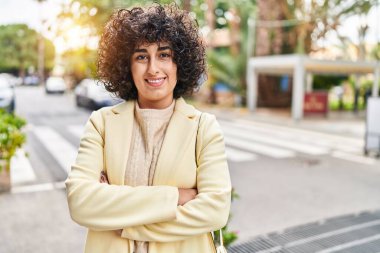 Young middle east woman excutive smiling confident standing with arms crossed gesture at street