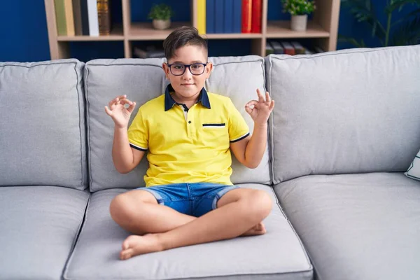 Adorable Hispanic Boy Doing Yoga Exercise Sitting Sofa Home — Fotografie, imagine de stoc