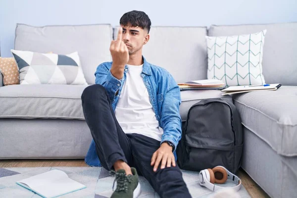 Young Hispanic Man Sitting Floor Studying University Showing Middle Finger — Stockfoto