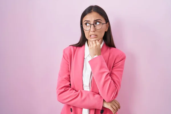 ビジネス服や眼鏡を身に着けている若いヒスパニック系の女性は 質問を心配し 顎に手で心配し — ストック写真
