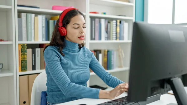在大学课堂上 年轻美丽的惊慌失措的女学生戴着耳机用计算机学习 — 图库照片