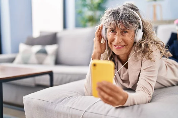 Middle Age Woman Listening Music Lying Sofa Home — Stockfoto