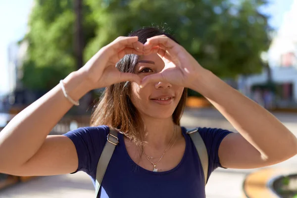 年轻的亚洲女人微笑着自信地用手在公园里做心形 — 图库照片
