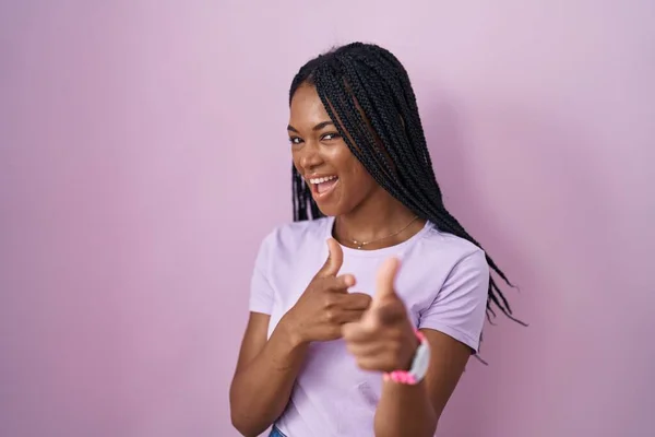 Африканская Американка Косичками Стоящая Розовом Фоне Указывая Пальцами Камеру Счастливым — стоковое фото