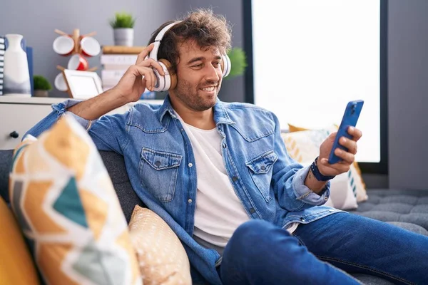 Jonge Spaanse Man Die Thuis Naar Muziek Luistert Zittend Bank — Stockfoto