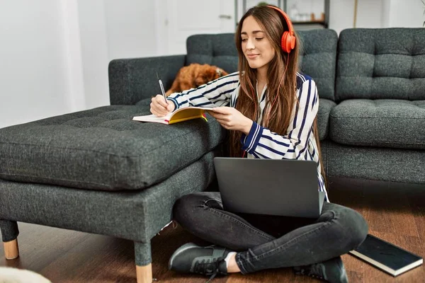 若いですヒスパニック女性使用してノートパソコン勉強床の上に座って犬とともに家に — ストック写真