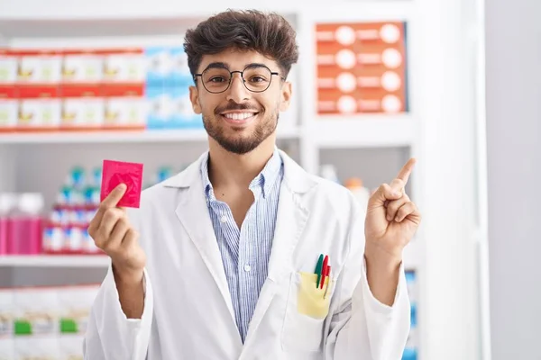 Homem Árabe Com Barba Trabalhando Farmácia Farmácia Farmácia Segurando Preservativo — Fotografia de Stock