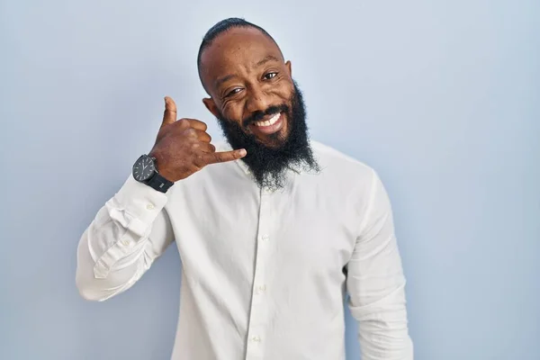 Mavi Arka Planda Dikilmiş Gülümseyen Afro Amerikan Bir Adam Telefonla — Stok fotoğraf