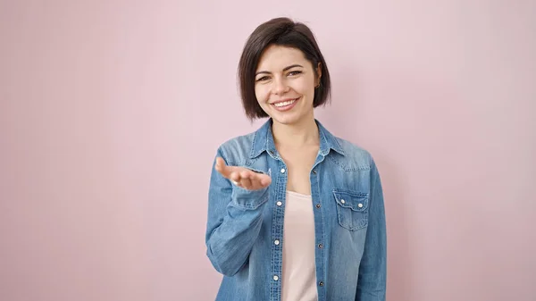 Jovem Caucasiana Sorrindo Confiante Oferecendo Mão Sobre Fundo Rosa Isolado — Fotografia de Stock
