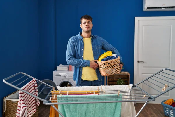 Young Hispanic Man Hanging Clothes Clothesline Thinking Attitude Sober Expression — Stock Photo, Image