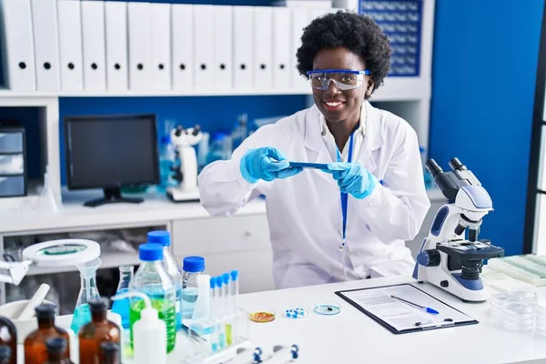 若いアフリカ系アメリカ人女性科学者が研究室でスマートフォンで写真を撮る — ストック写真