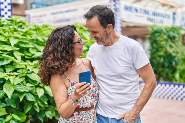 Άνδρας Και Γυναίκα Ζευγάρι Αγκαλιάζονται Χρησιμοποιώντας Smartphone Στο Πάρκο — Φωτογραφία Αρχείου