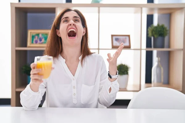 Μελαχρινή Γυναίκα Πίνει Ένα Ποτήρι Χυμό Πορτοκάλι Τρελό Και Τρελό — Φωτογραφία Αρχείου