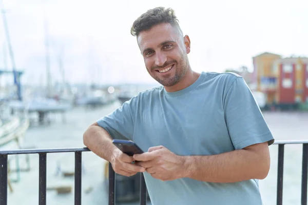 Genç Spanyol Adam Deniz Kenarında Akıllı Telefon Kullanarak Gülümsüyor — Stok fotoğraf