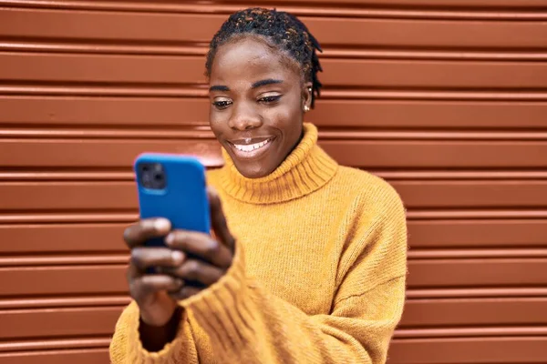 非洲裔美国女人在街上用智能手机充满自信地微笑 — 图库照片