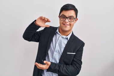 Down sendromlu genç İspanyol adam. İş stili jest yapıyor. Elleri büyük ve büyük boy işareti gösteriyor. Kameraya bakıp gülümsüyor. ölçüm kavramı. 