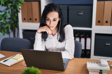 Young caucasian woman business worker using laptop and earphones working at office