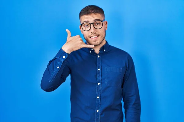 Mladý Hispánec Brýlích Nad Modrým Pozadím Usmívá Gestikuluje Rukama Prsty — Stock fotografie