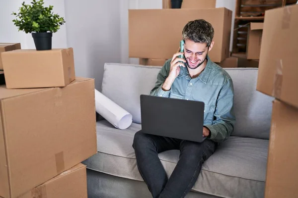 Young Man Using Laptop Talking Smartphone New Home — Stock Photo, Image
