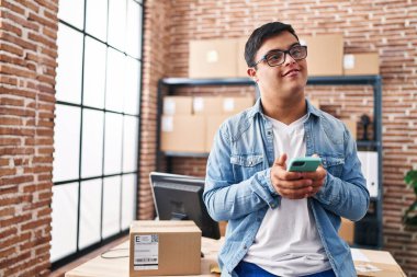 Down sendromlu adam iş adamı ofisteki akıllı telefonu kullanıyor.